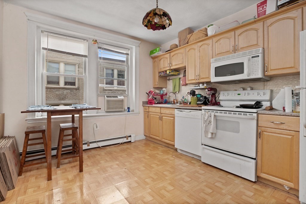 32 Ransom Road, Unit 10 Boston, MA 02135 - Photo 5 of 12 a kitchen with white cabinets and window