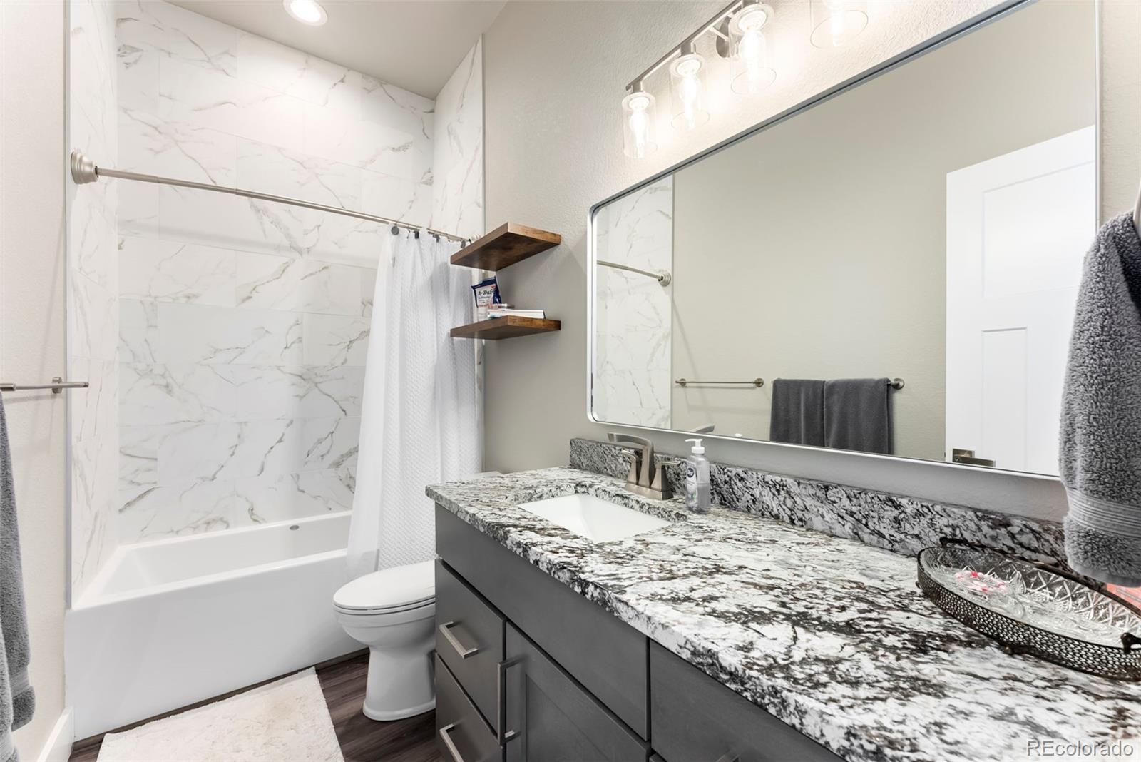 489 Duesouth Road Florissant, CO 80816 - Photo 22 of 40 a bathroom with a granite countertop sink a toilet and shower