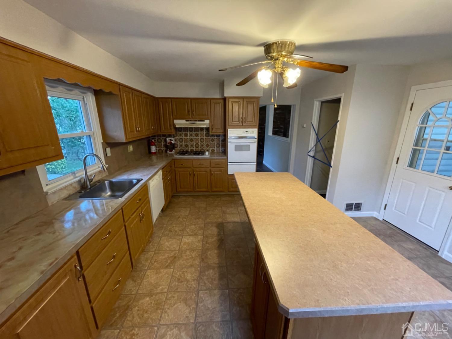 122 Princeton Road Old Bridge, NJ 08859 - Photo 25 of 40 a large kitchen with stainless steel appliances kitchen island granite countertop a sink dishwasher and a flat tv screen next to a window