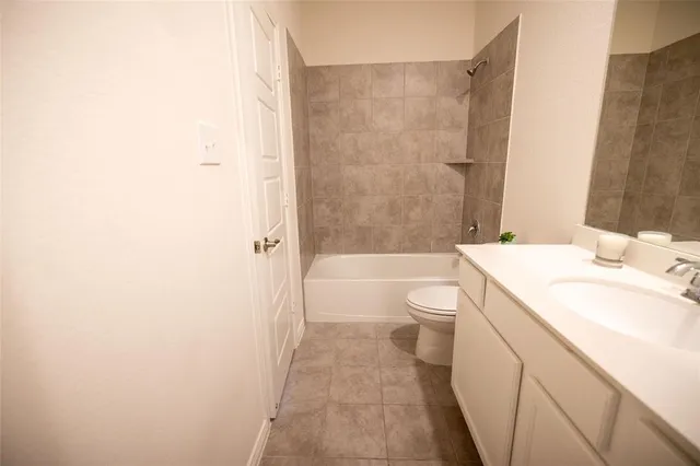 a bathroom with a granite countertop sink a toilet and shower