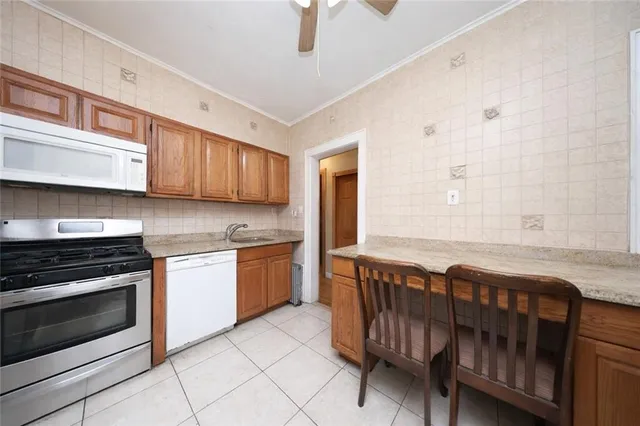 a kitchen with stainless steel appliances granite countertop a stove a sink and a microwave