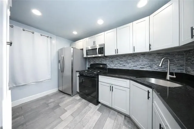 a kitchen with stainless steel appliances granite countertop a sink stove and refrigerator