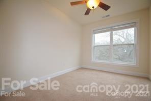1409 Riverside Drive Charlotte, NC 28214 - Photo 19 of 23 an empty room with a chandelier fan and windows