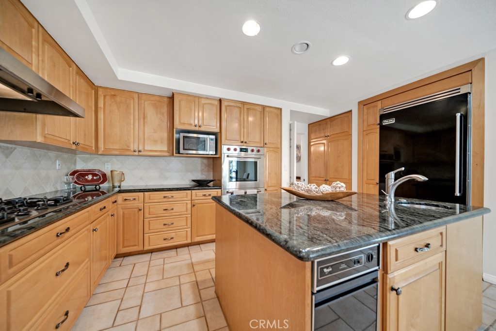 18845 Beechtree Lane Porter Ranch, CA 91326 - Photo 10 of 41 a kitchen with stainless steel appliances granite countertop a stove sink and cabinets