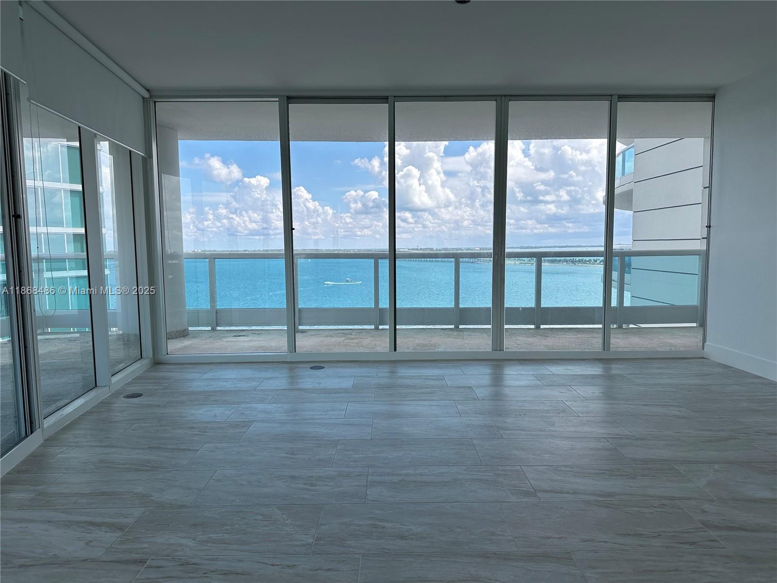 2127 Brickell Avenue, Unit 1504 Miami, FL 33129 - Photo 11 of 44 a view of an empty room with glass door and windows