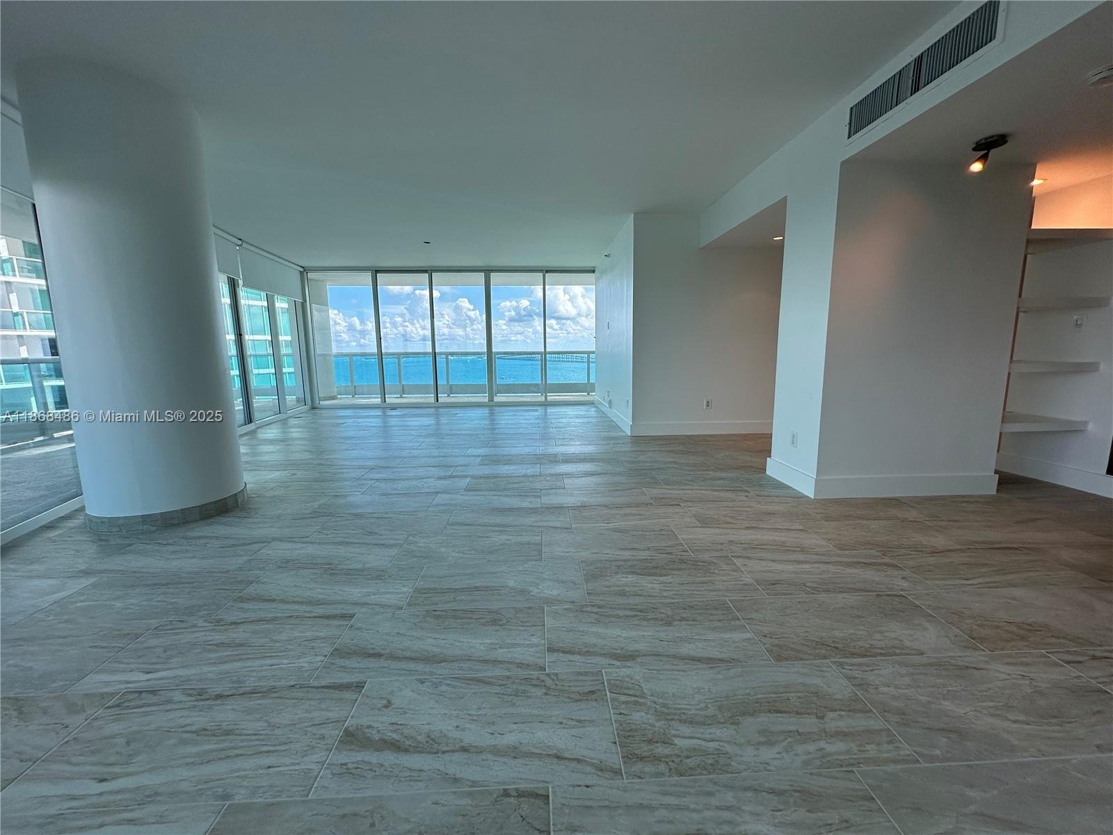 2127 Brickell Avenue, Unit 1504 Miami, FL 33129 - Photo 13 of 44 an empty room with wooden floor and windows