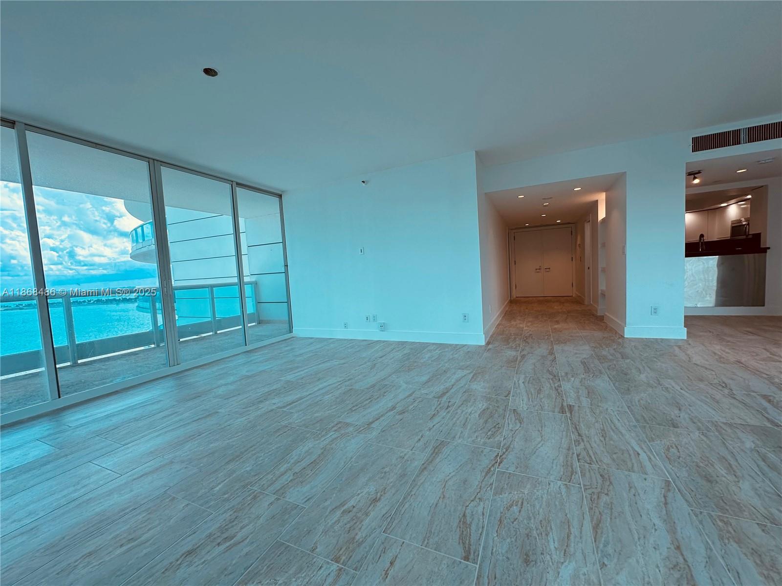 2127 Brickell Avenue, Unit 1504 Miami, FL 33129 - Photo 14 of 44 an empty room with wooden floor and windows