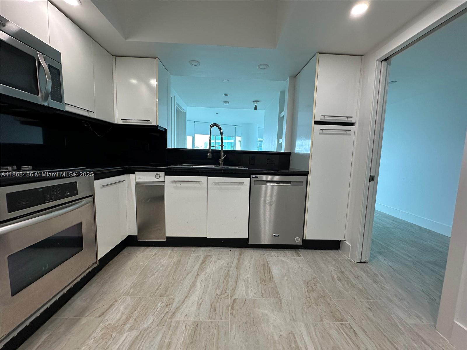 2127 Brickell Avenue, Unit 1504 Miami, FL 33129 - Photo 16 of 44 a kitchen with stainless steel appliances a stove a microwave and a hard wood floors