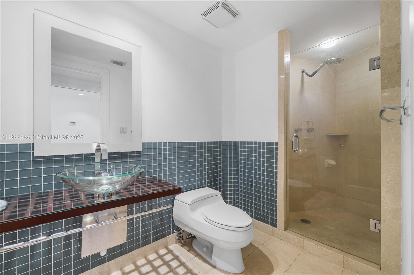 2127 Brickell Avenue, Unit 1504 Miami, FL 33129 - Photo 18 of 44 a bathroom with a granite countertop toilet a sink a mirror and shower