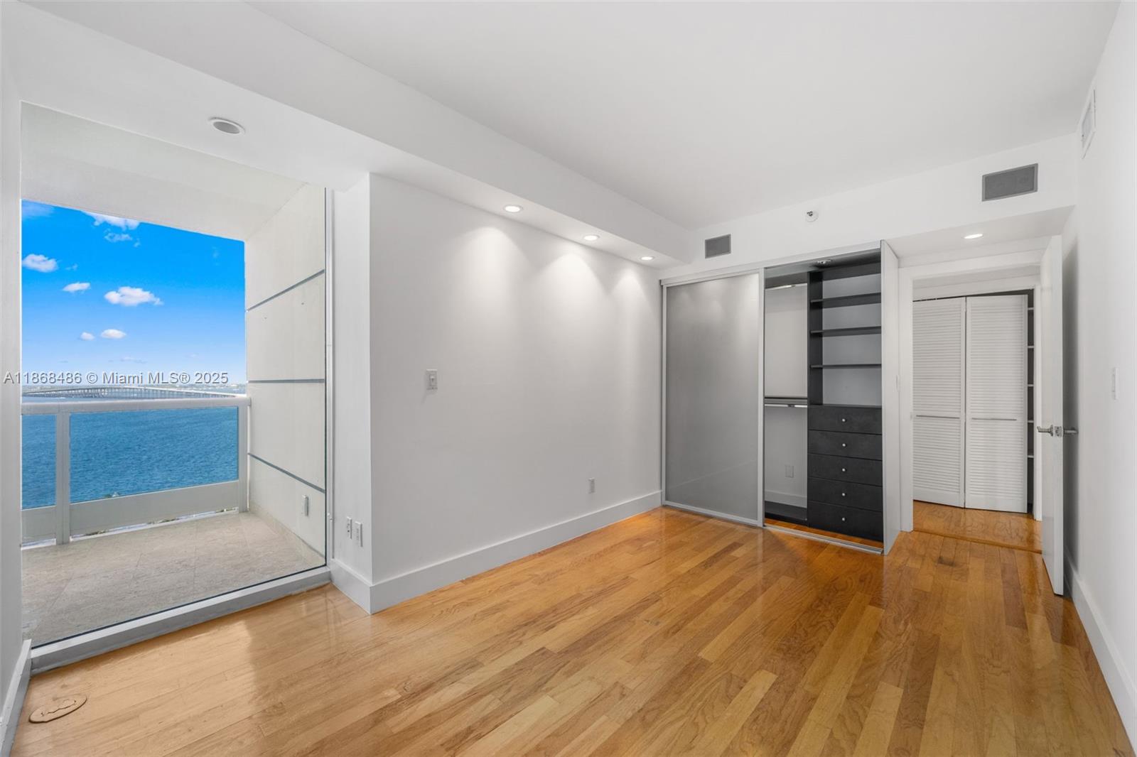 2127 Brickell Avenue, Unit 1504 Miami, FL 33129 - Photo 20 of 44 a view of an empty room with wooden floor and a window