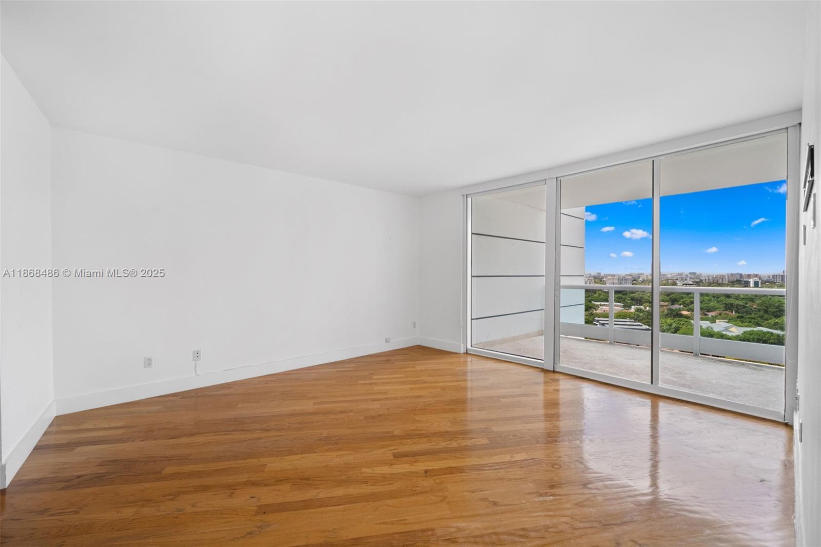 2127 Brickell Avenue, Unit 1504 Miami, FL 33129 - Photo 24 of 44 a view of empty room with wooden floor and sliding window