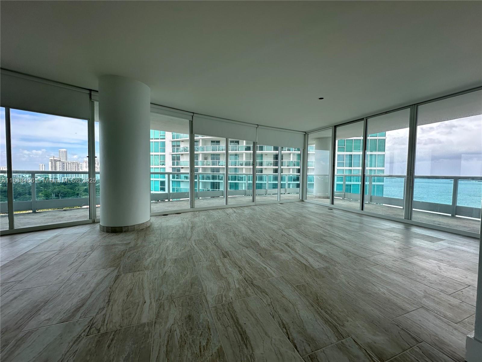 2127 Brickell Avenue, Unit 1504 Miami, FL 33129 - Photo 8 of 44 an empty room with wooden floor and windows