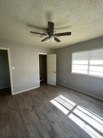 a view of an empty room and window and wooden floor
