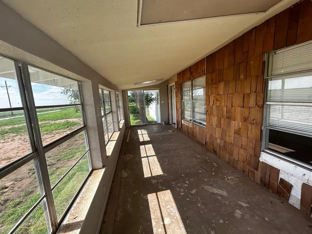a view of a large room with wooden floor and windows