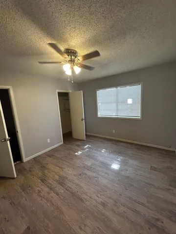 an empty room with windows and fan