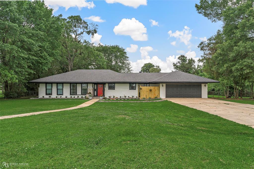 a view of a house with a big yard and large trees
