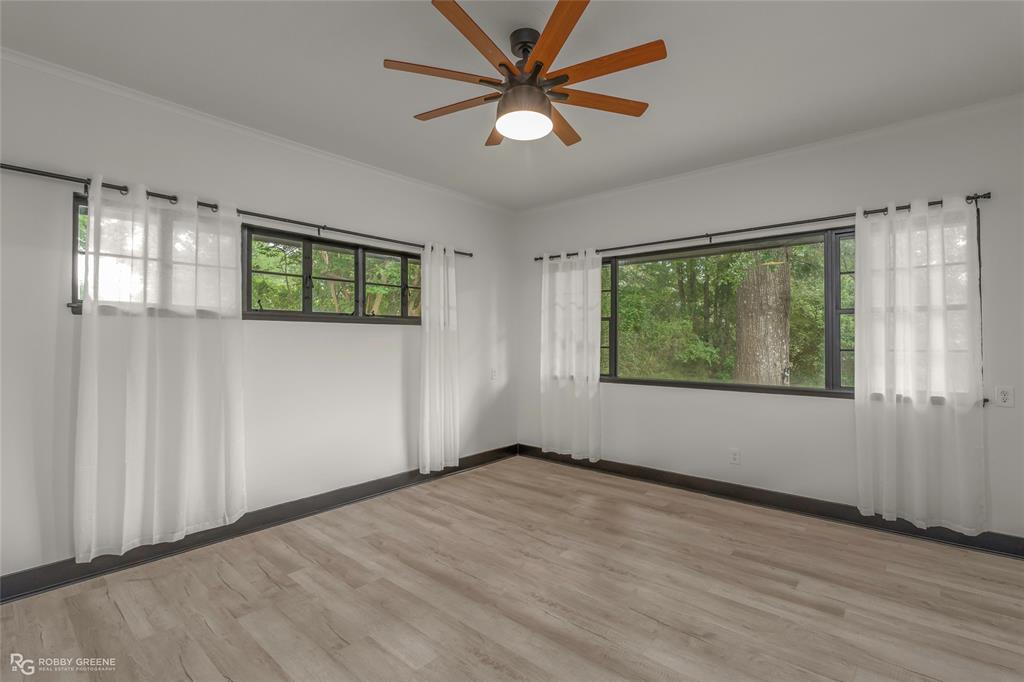 207 Red River Street Benton, LA 71006 - Photo 12 of 29 a view of an empty room with a window and wooden floor