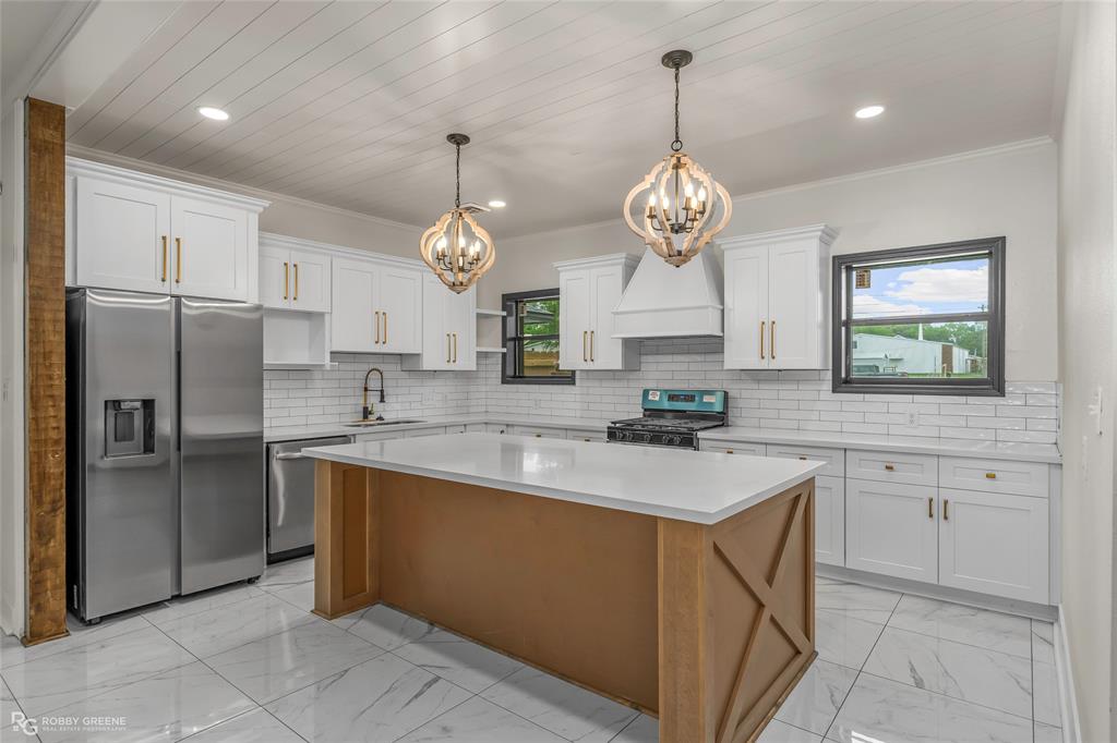 207 Red River Street Benton, LA 71006 - Photo 8 of 29 a kitchen with cabinets stainless steel appliances and a chandelier