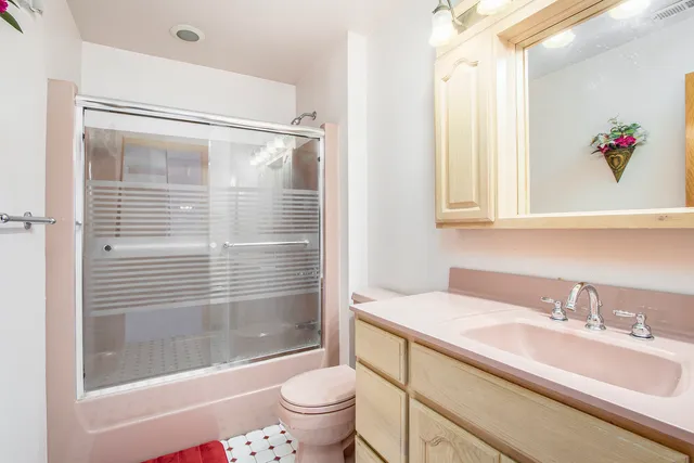 a bathroom with a bathtub shower sink vanity and toilet