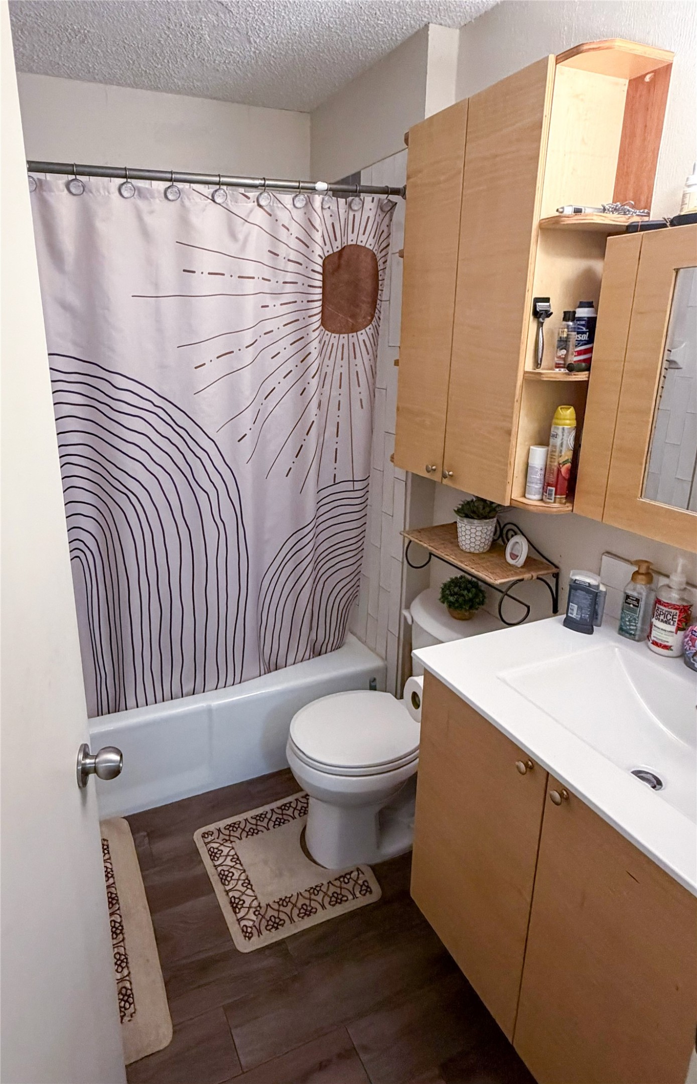 911 Kirschner Place, Unit A Austin, TX 78758 - Photo 11 of 12 Functional bathroom features a tub-shower combination, a vanity with a sink, and wall-mounted storage.