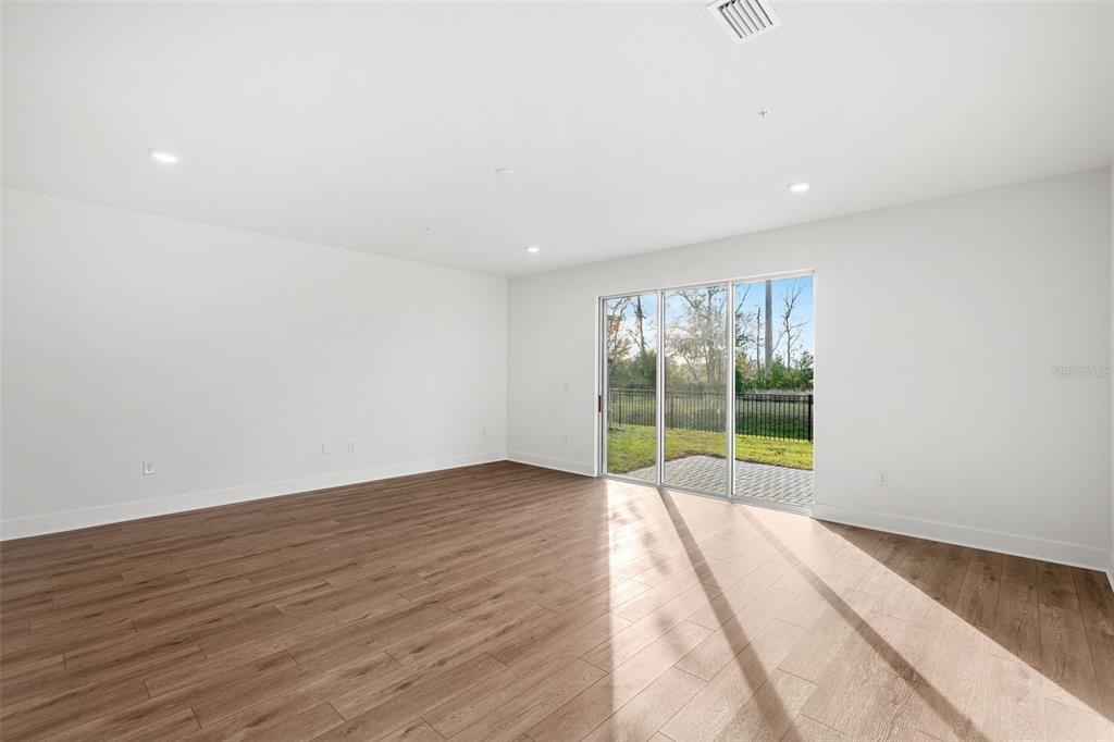 2438 Magnolia Reserve Road Ocoee, FL 34761 - Photo 14 of 26 a view of an empty room with wooden floor and a window