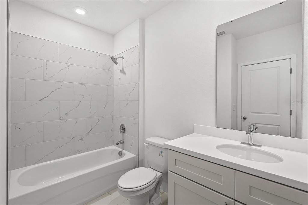 2438 Magnolia Reserve Road Ocoee, FL 34761 - Photo 19 of 26 a bathroom with a granite countertop sink a toilet and shower