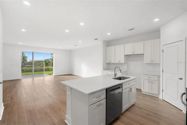 a large kitchen with stainless steel appliances and white cabinets