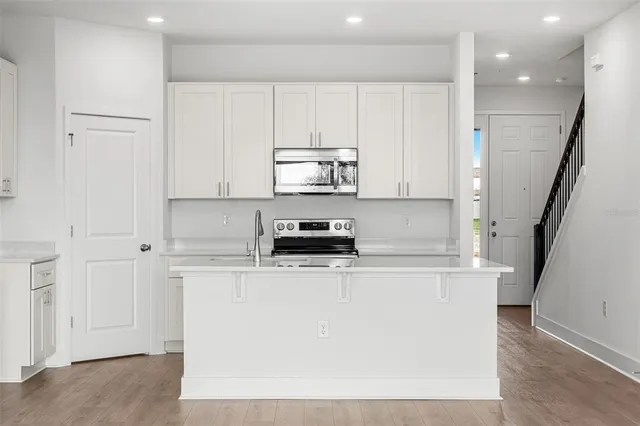 a kitchen with stainless steel appliances a refrigerator and a stove top oven