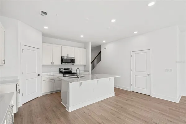 a kitchen with stainless steel appliances granite countertop a sink and a microwave