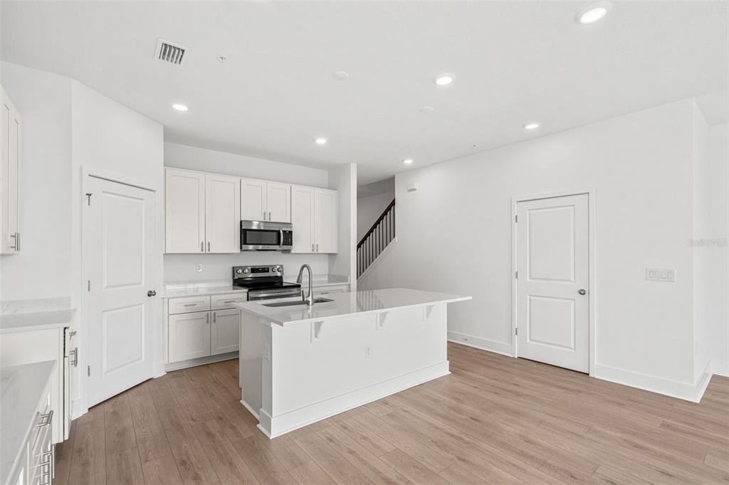 2438 Magnolia Reserve Road Ocoee, FL 34761 - Photo 9 of 26 a kitchen with stainless steel appliances a refrigerator and a stove top oven