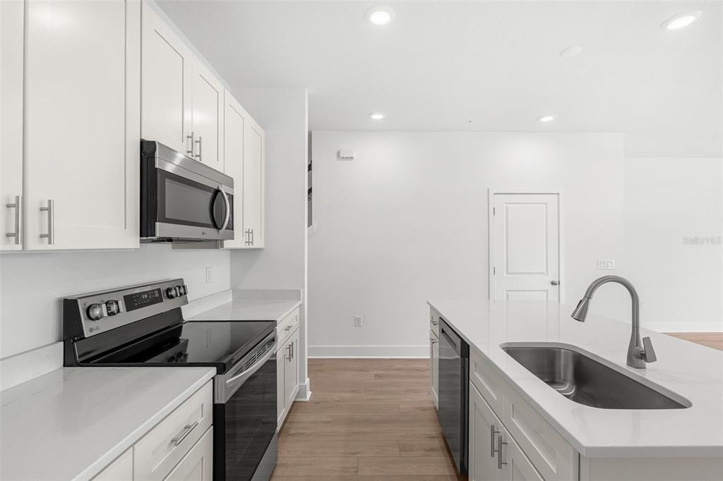 2438 Magnolia Reserve Road Ocoee, FL 34761 - Photo 10 of 26 a kitchen with stainless steel appliances granite countertop a sink and a microwave
