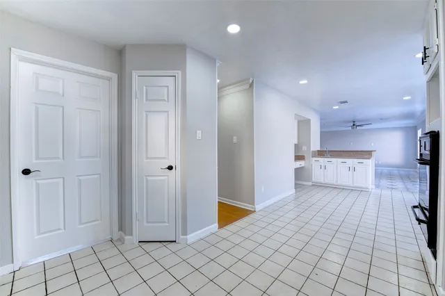 a kitchen with granite countertop white cabinets white appliances a sink and a window