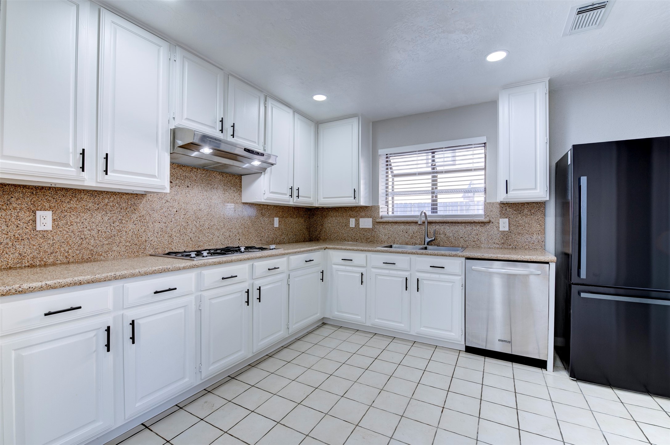 11434 High Bridge Court Houston, TX 77065 - Photo 13 of 31 a kitchen with granite countertop white cabinets white appliances a sink and a window