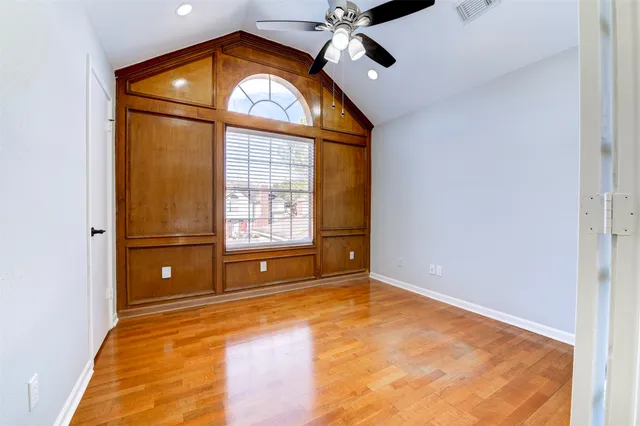 a view of an empty room with window and wooden floor