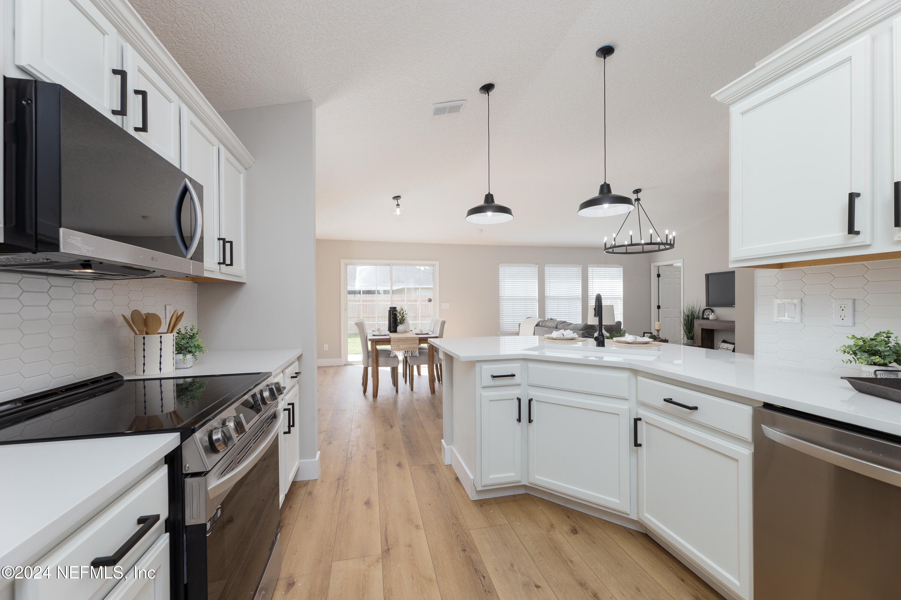 9542 Staples Mill Drive Jacksonville, FL 32244 - Photo 11 of 33 a kitchen with stainless steel appliances a sink a stove and a wooden floors
