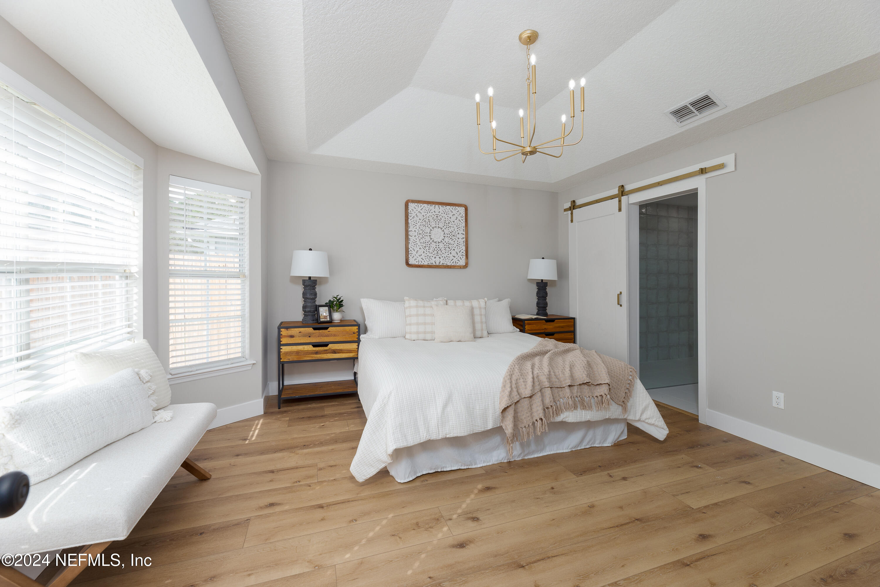 9542 Staples Mill Drive Jacksonville, FL 32244 - Photo 16 of 33 a bedroom with a bed and a chandelier