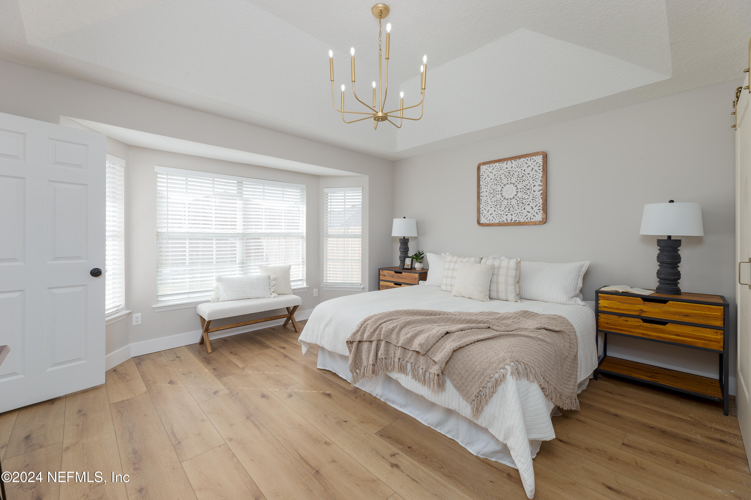 9542 Staples Mill Drive Jacksonville, FL 32244 - Photo 17 of 33 a spacious bedroom with a bed and a chandelier