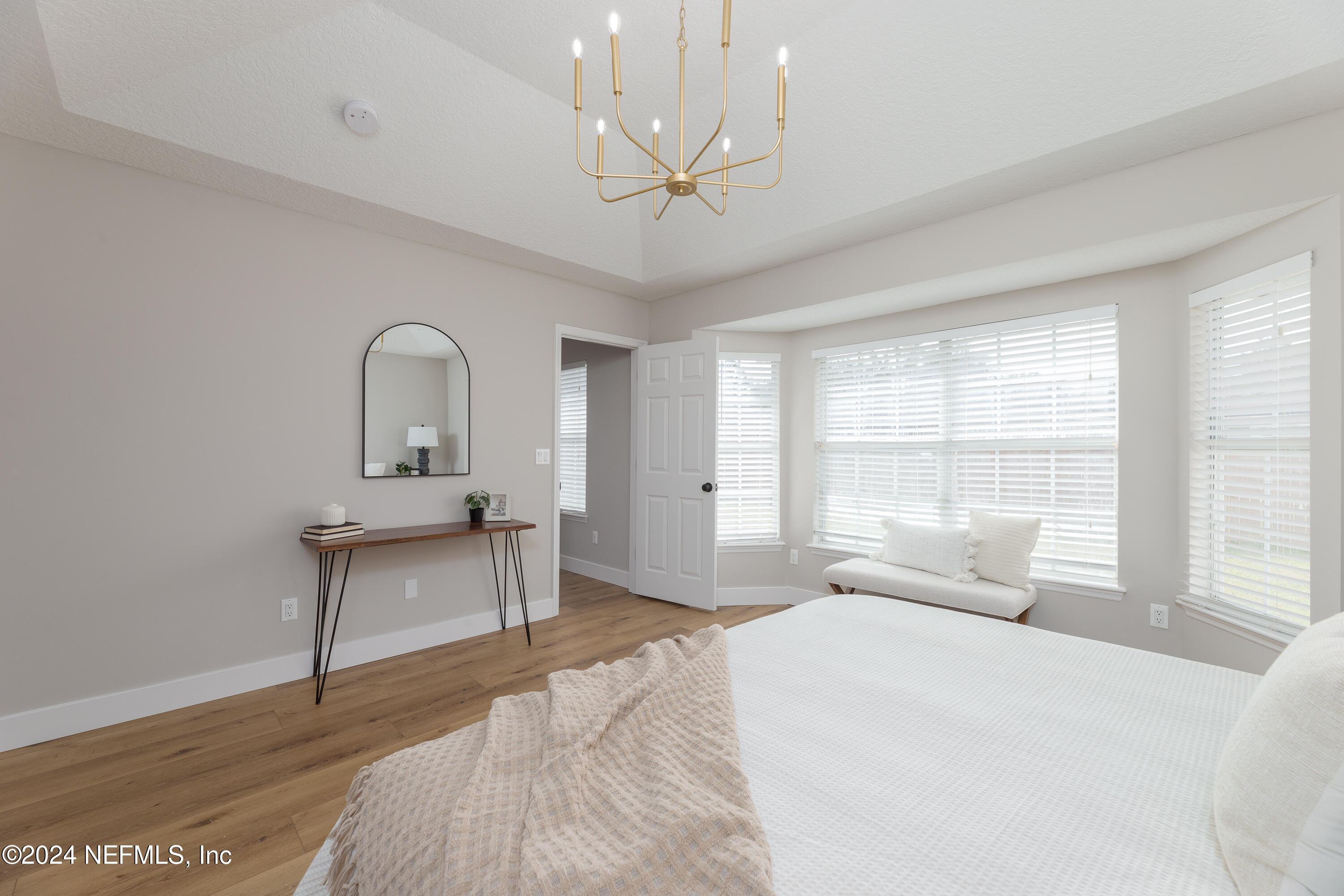 9542 Staples Mill Drive Jacksonville, FL 32244 - Photo 19 of 33 a bedroom with a bed wooden floor and a large window