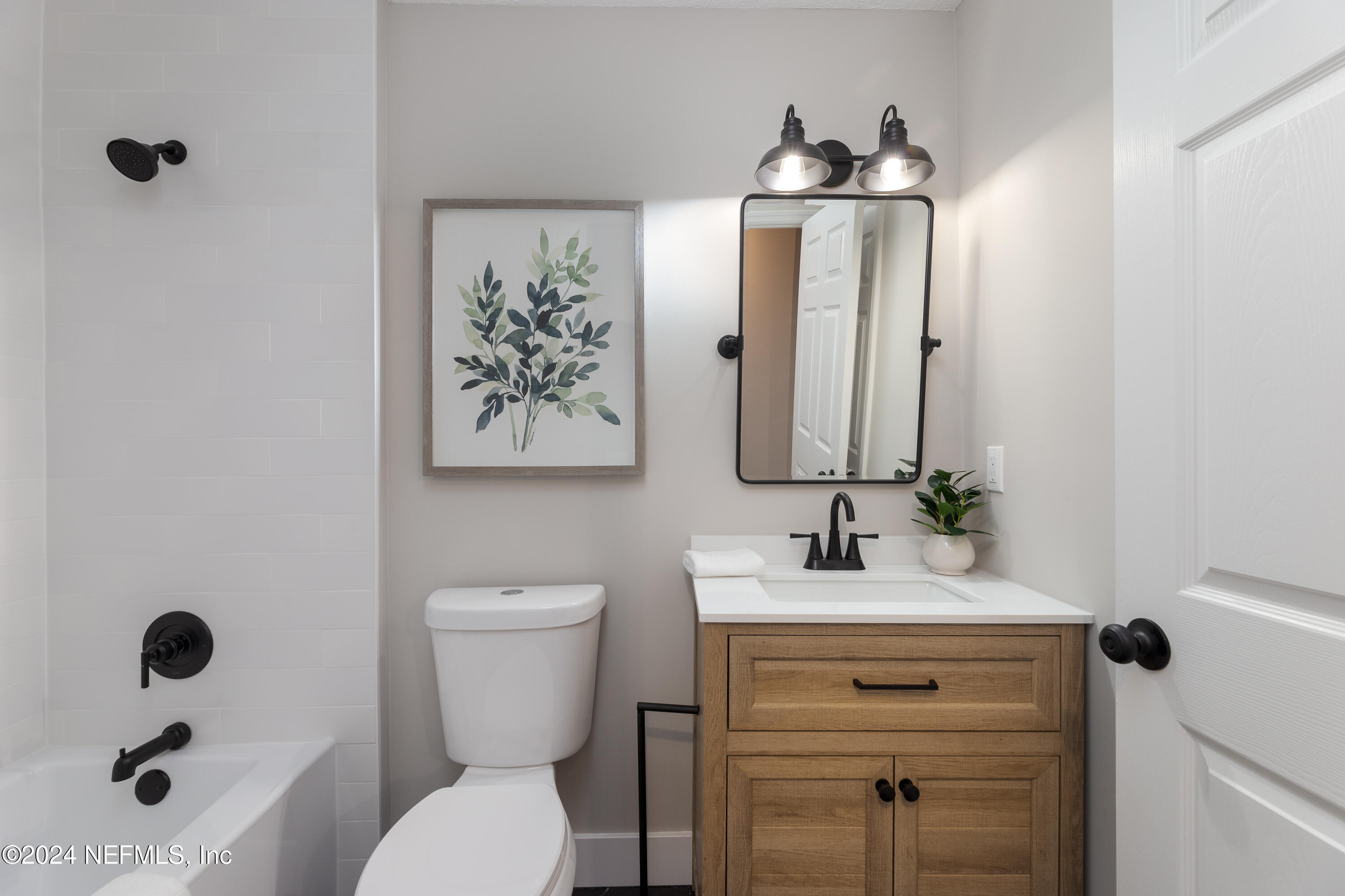 9542 Staples Mill Drive Jacksonville, FL 32244 - Photo 23 of 33 a bathroom with a toilet sink and mirror