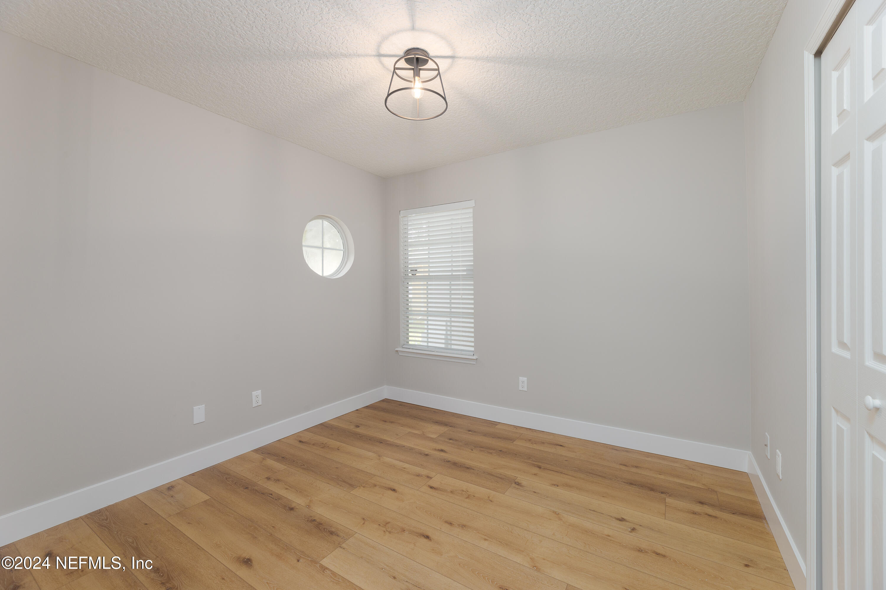 9542 Staples Mill Drive Jacksonville, FL 32244 - Photo 26 of 33 a view of empty room with wooden floor and fan