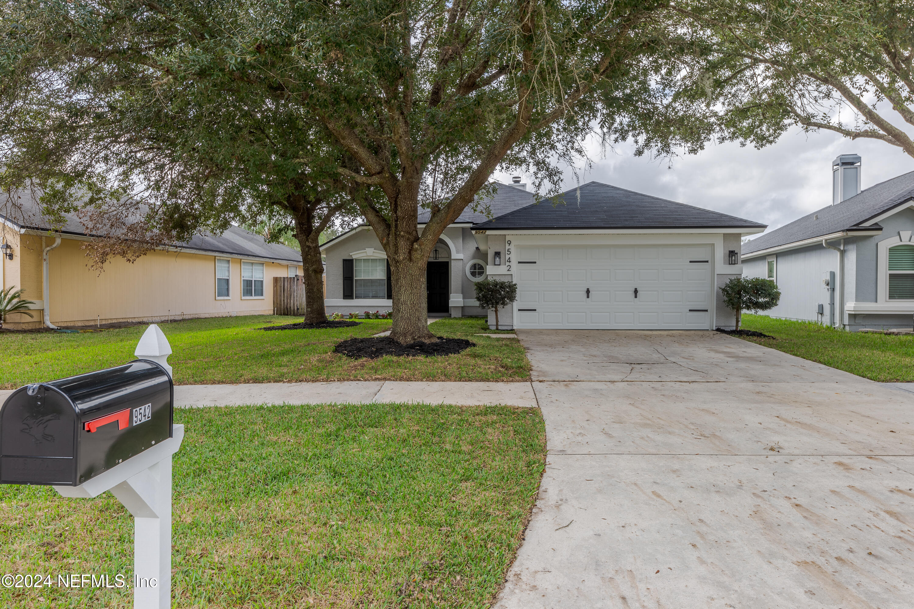 9542 Staples Mill Drive Jacksonville, FL 32244 - Photo 4 of 33 a front view of a house with a garden and tree