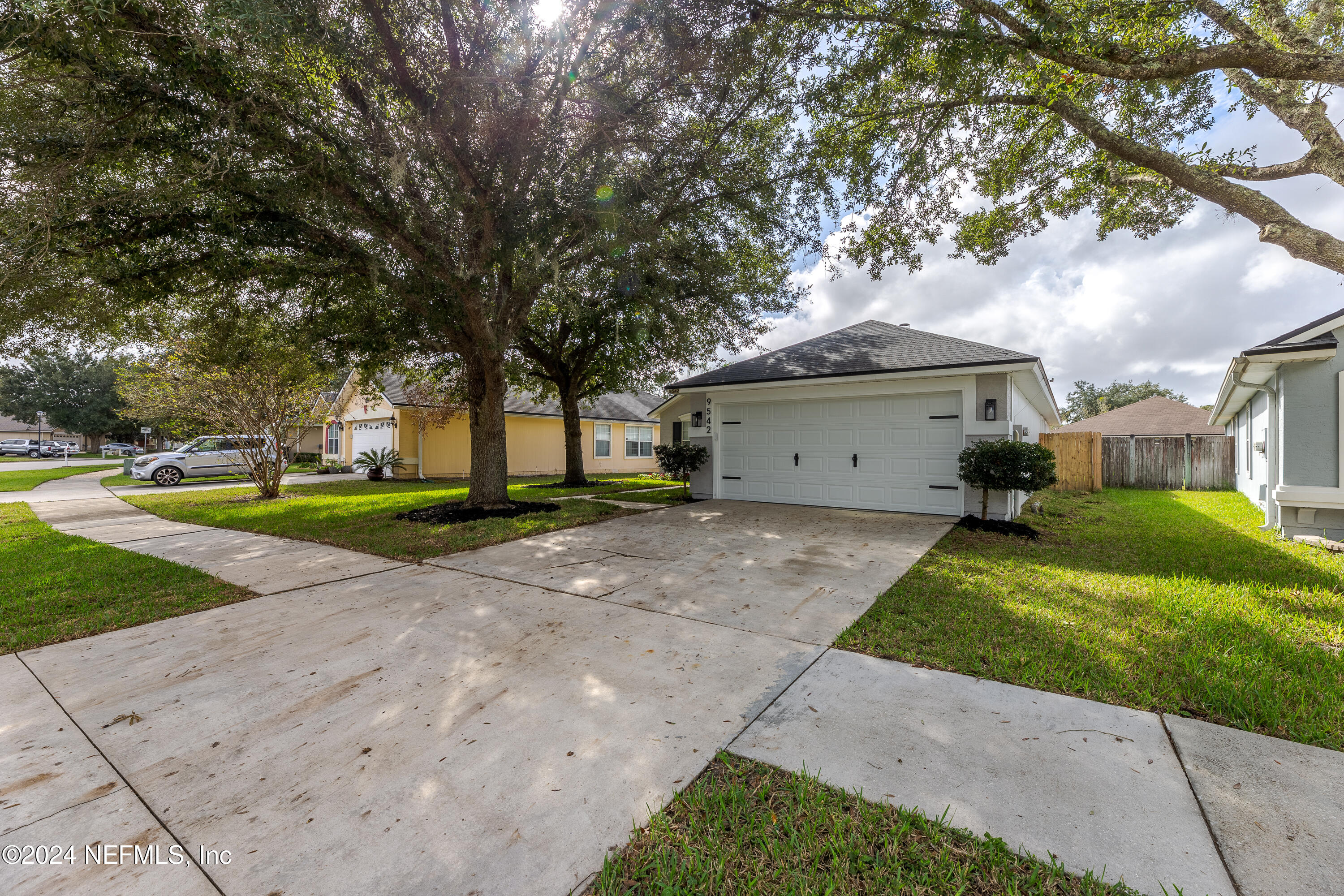 9542 Staples Mill Drive Jacksonville, FL 32244 - Photo 5 of 33 a front view of a house with a garden and trees