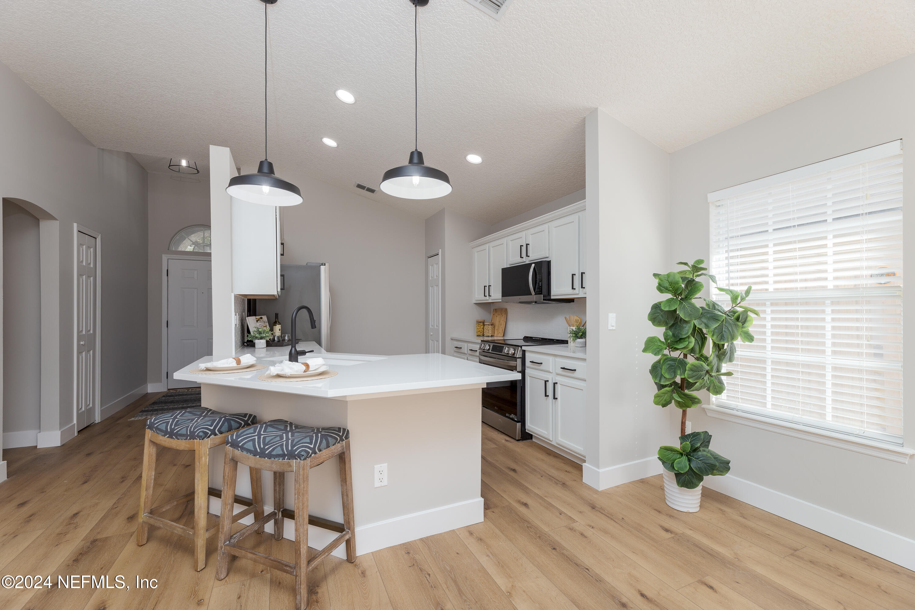 9542 Staples Mill Drive Jacksonville, FL 32244 - Photo 10 of 33 a kitchen with kitchen island stainless steel appliances a sink stove and refrigerator