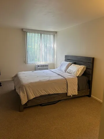 a bed sitting in a bedroom next to a window