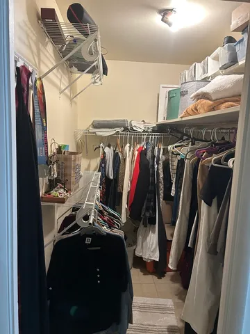 a view of walk in closet with clothes and shoes