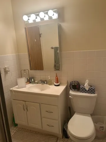 a bathroom with a toilet sink and mirror