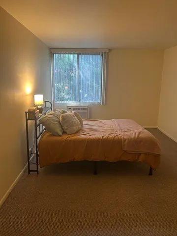 a bed sitting in a bedroom next to a window