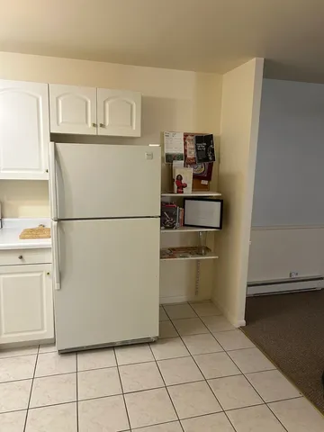 a white refrigerator freezer and a stove sitting inside of a kitchen