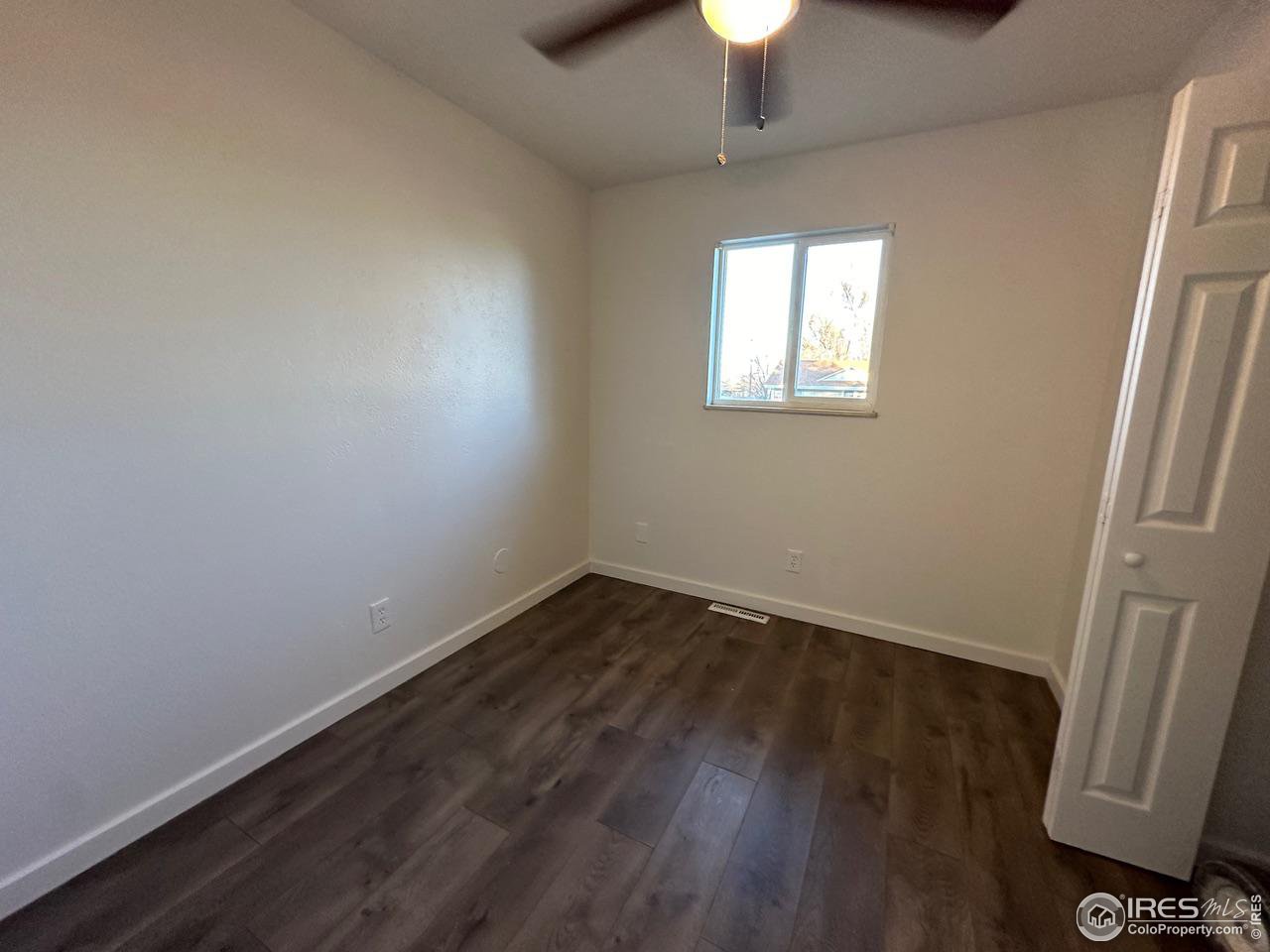 3209 5th Road Greeley, CO 80634 - Photo 12 of 37 an empty room with wooden floor and windows