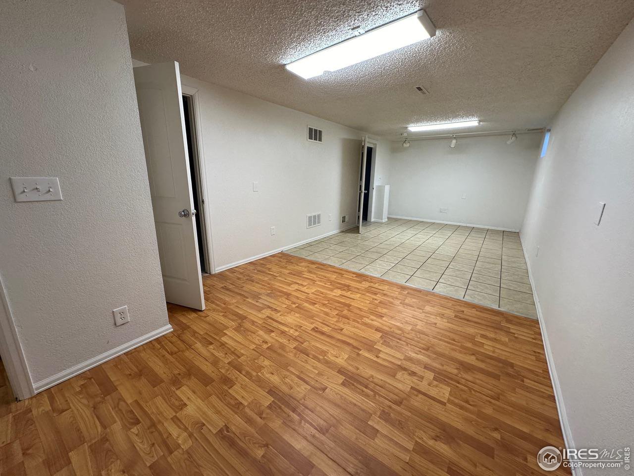 3209 5th Road Greeley, CO 80634 - Photo 13 of 37 an empty room with wooden floor and entrance